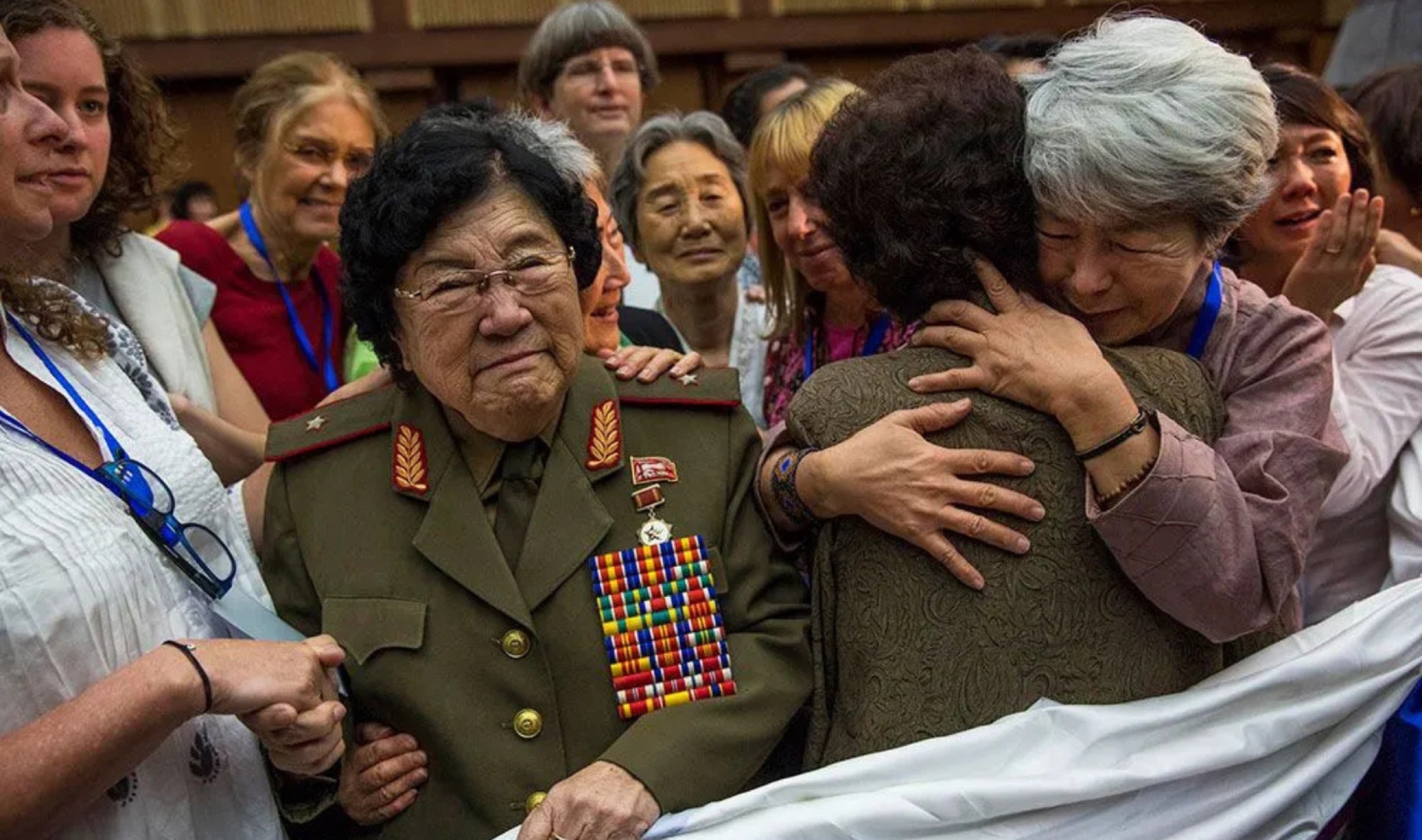 Women embrace at a quilt-stitching ceremony at the Women's Peace Symposium in Pyongyang